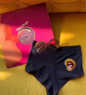 Open image in slideshow, Highwaist Cheeky Shorts in Stretch Denim with &quot;Love is my Drug&quot; Patch
